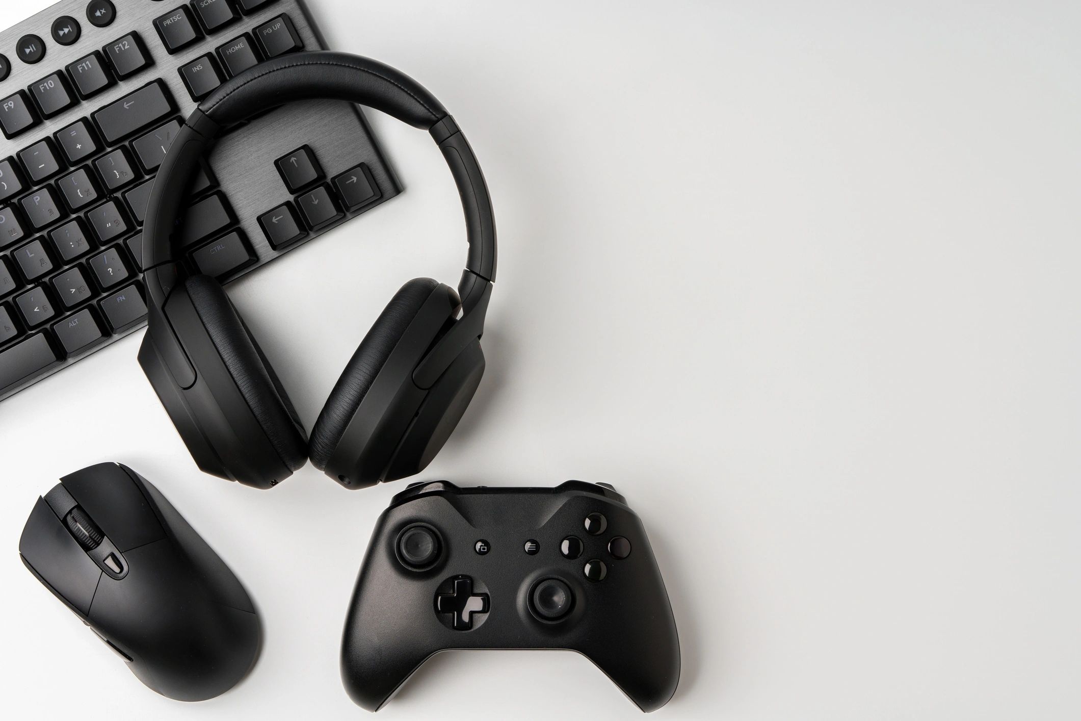 Gaming desk with keyboard, joystick, and headphones